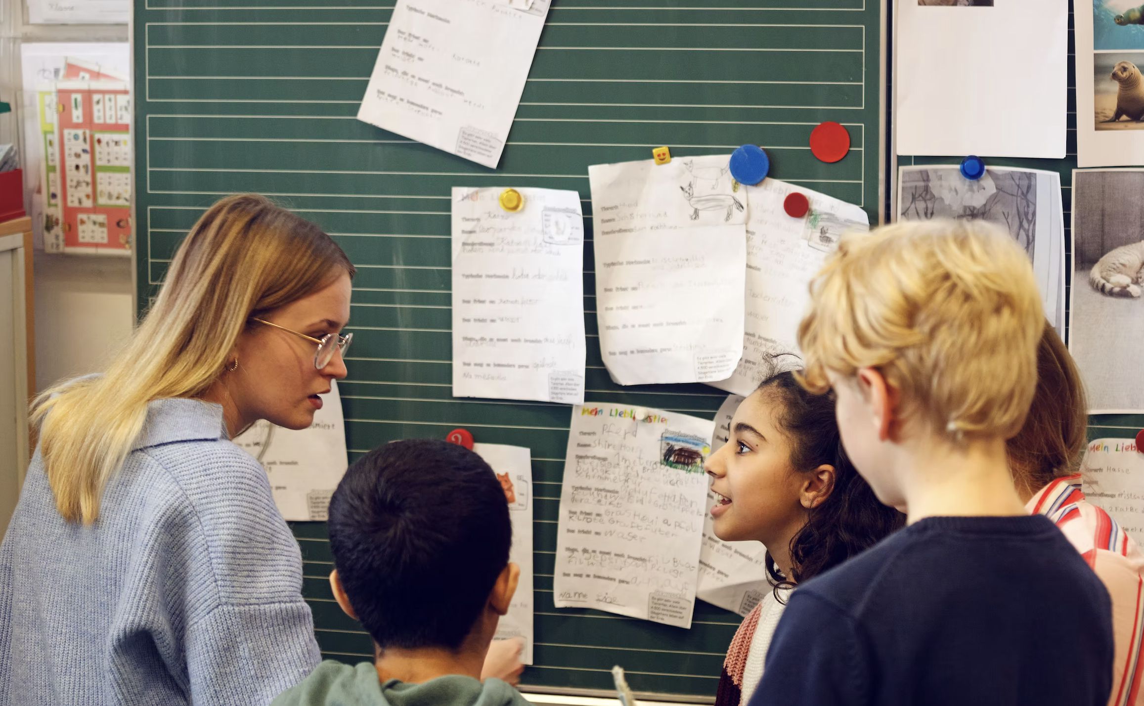 Kinder lesen an einer Tafel.
