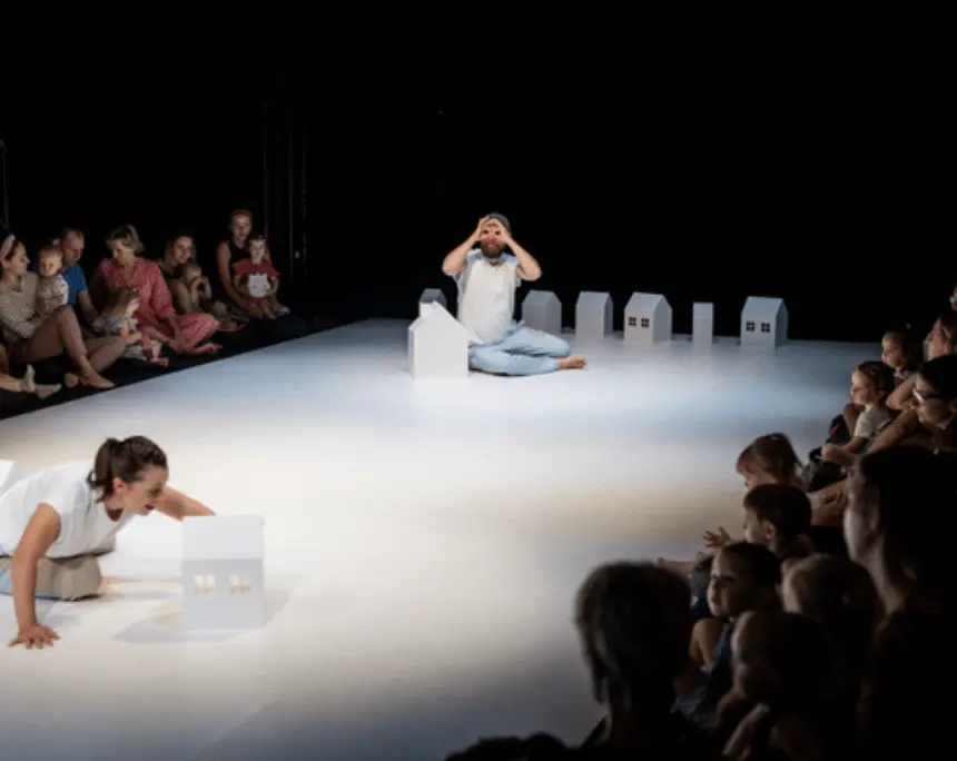 Theateraufführung mit Kindern und Häusern.
