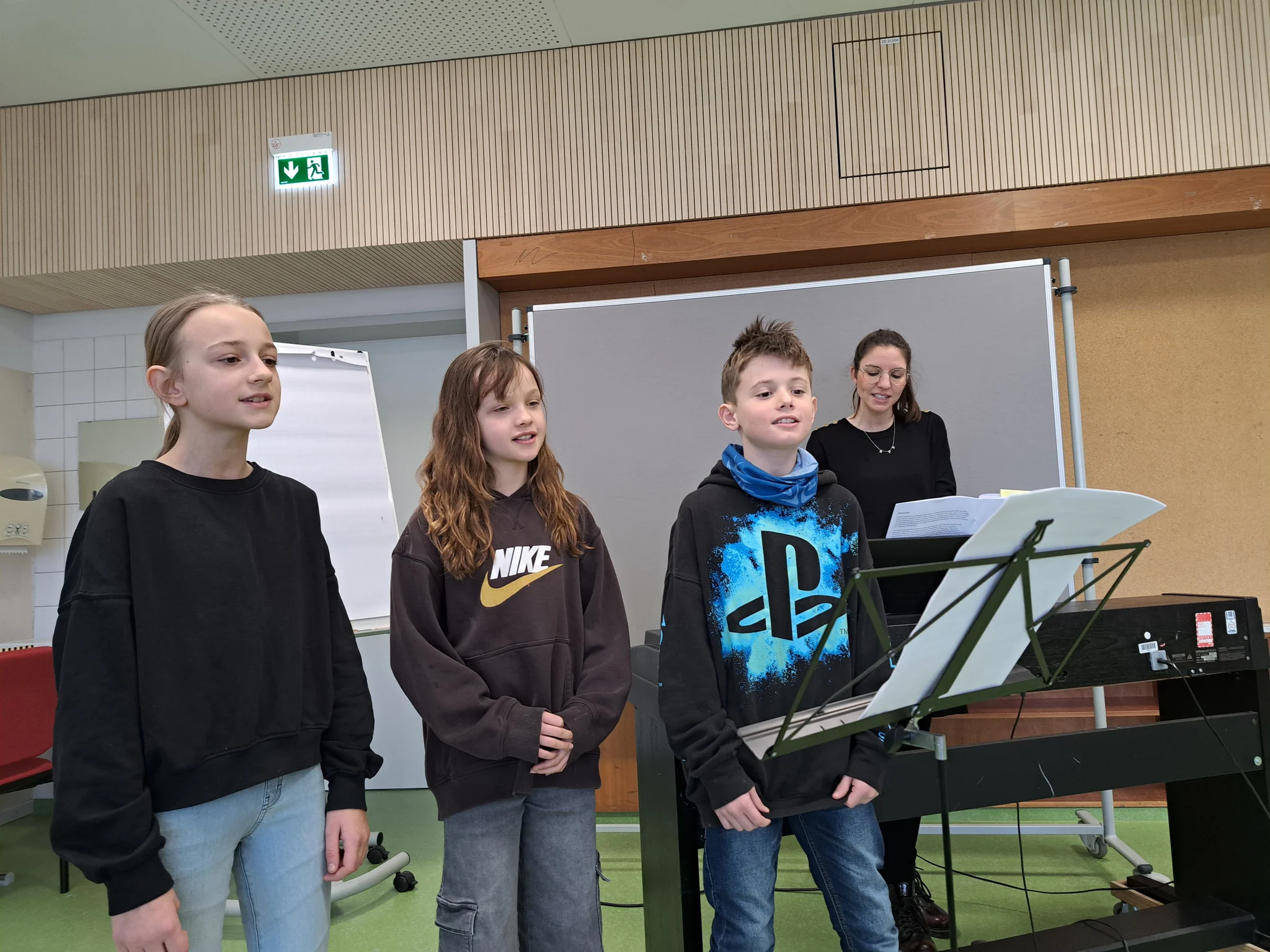 Kinder singen vor einer Gruppe.